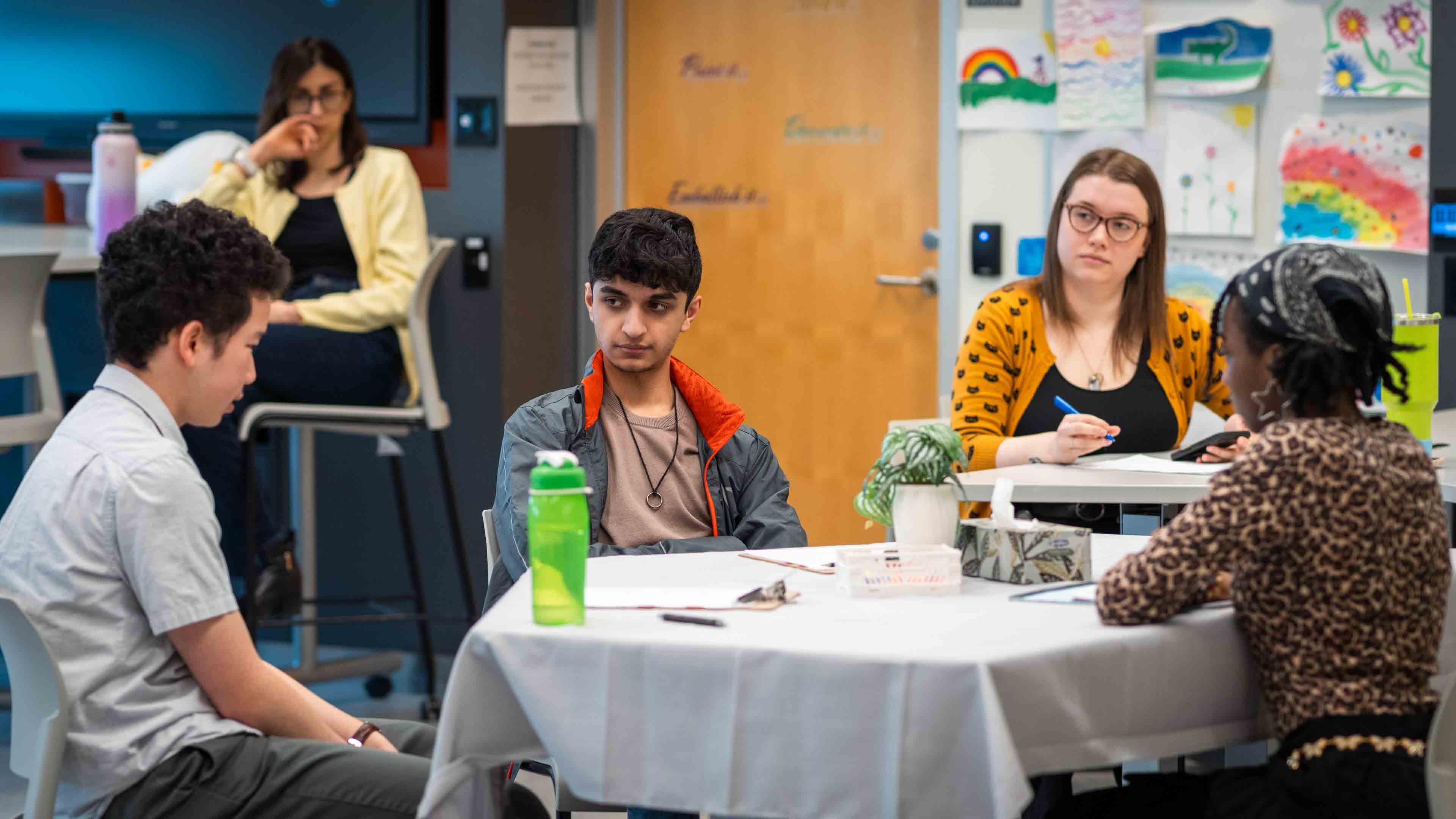 People gather around the table observing the simulated counselling session
