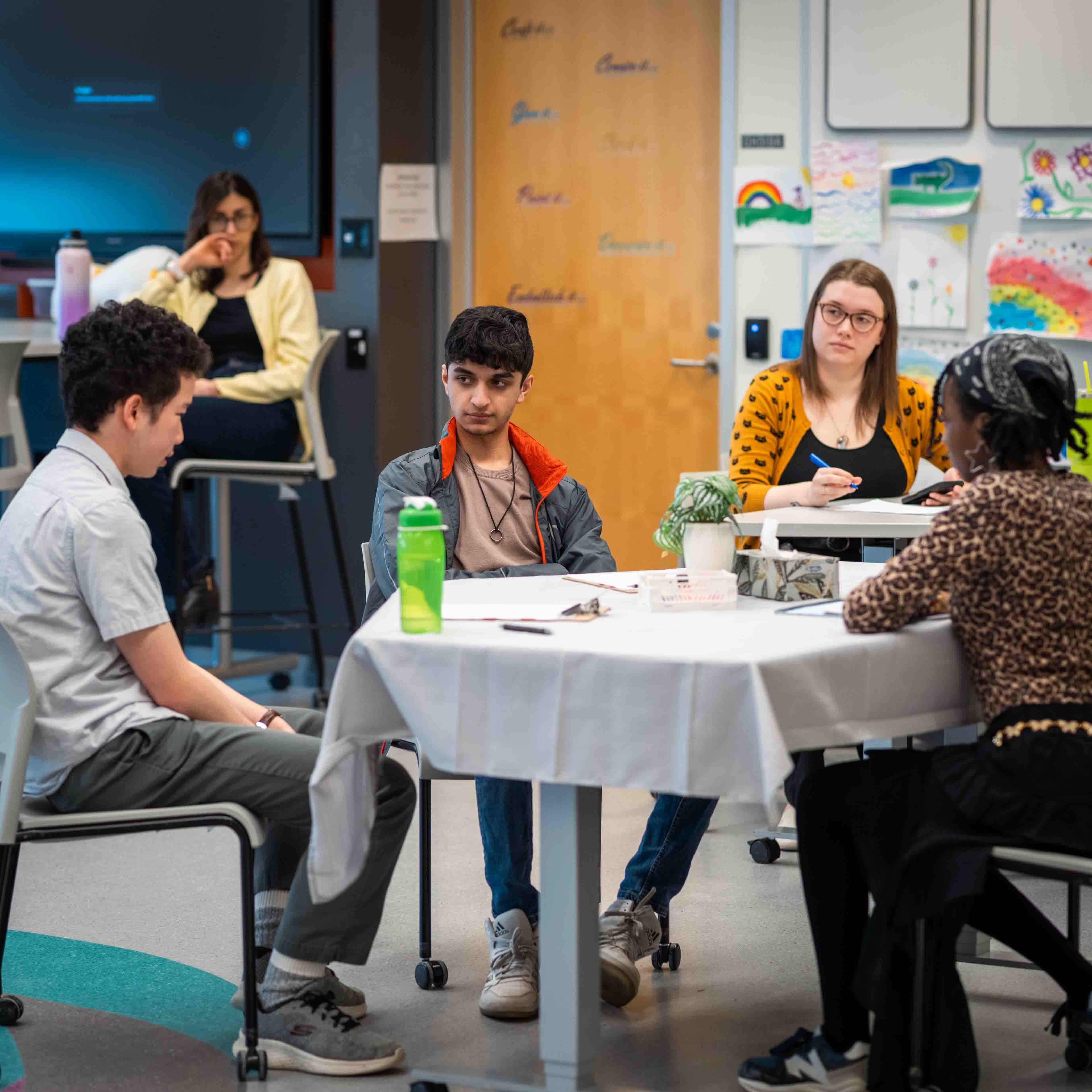 People gather around the table observing the simulated counselling session
