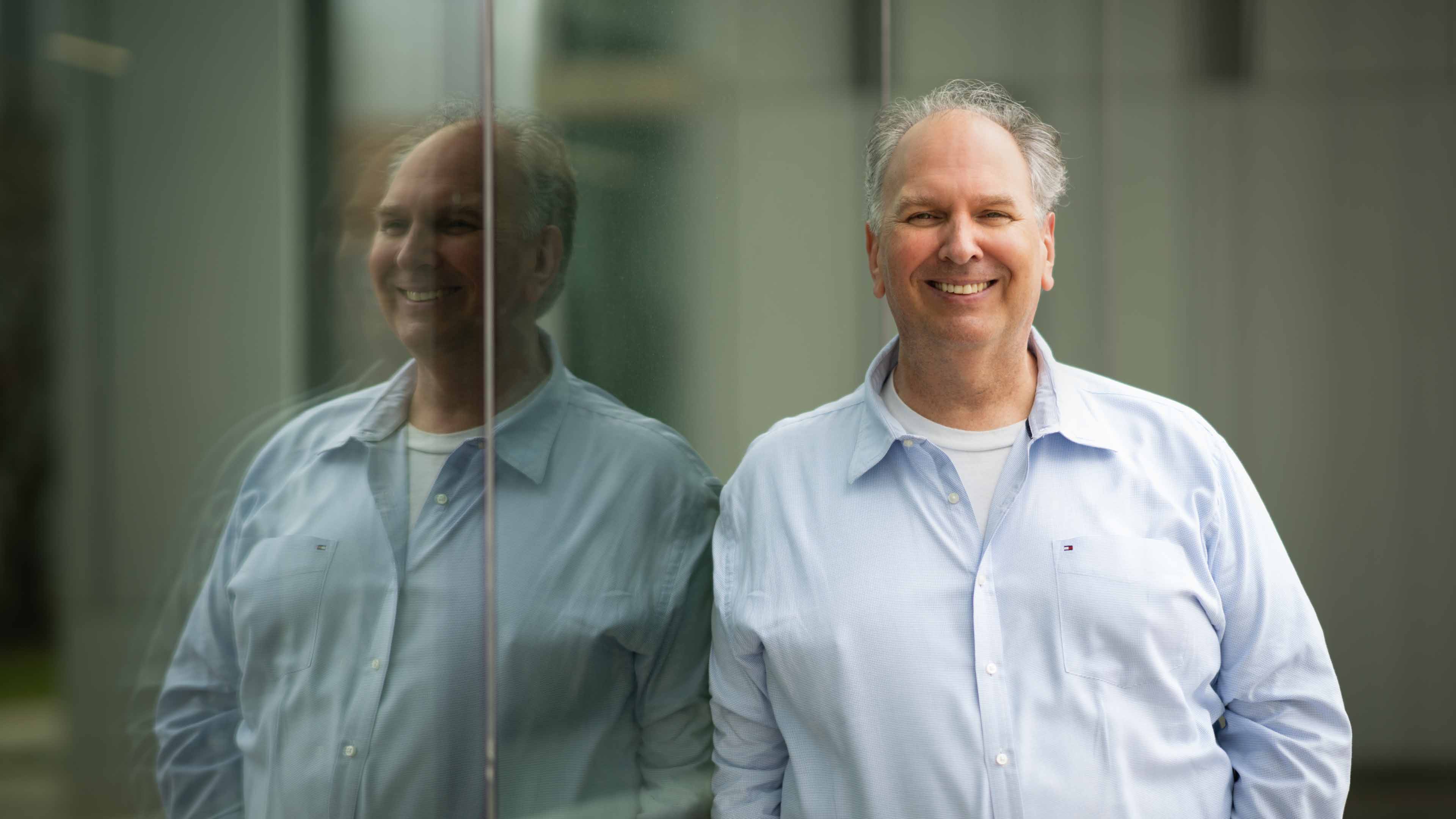 Charlie Janthur wears a blue dress shirt and smiles