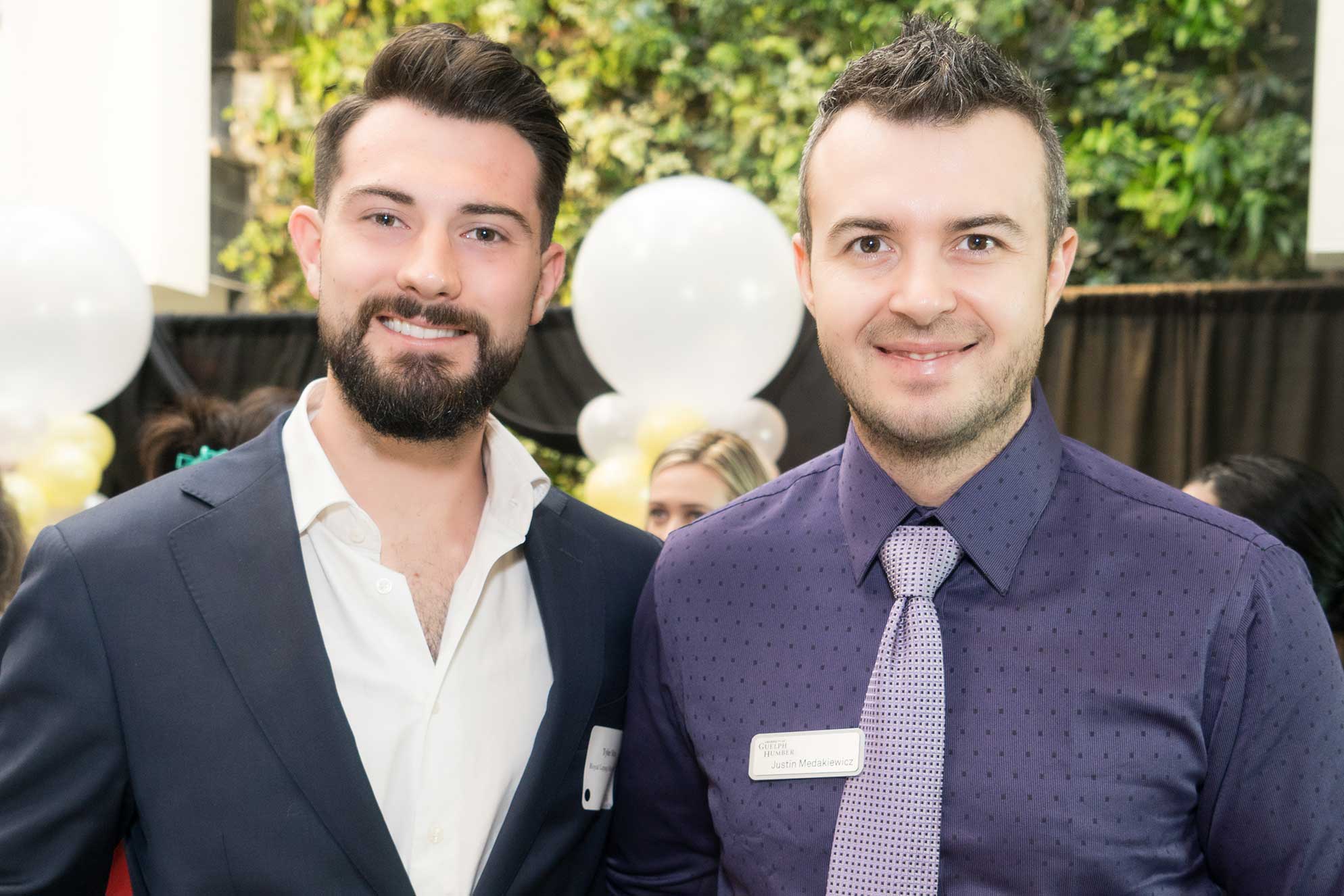 Business Assistant Program Head Justin Medakiewicz smiles with a guest 