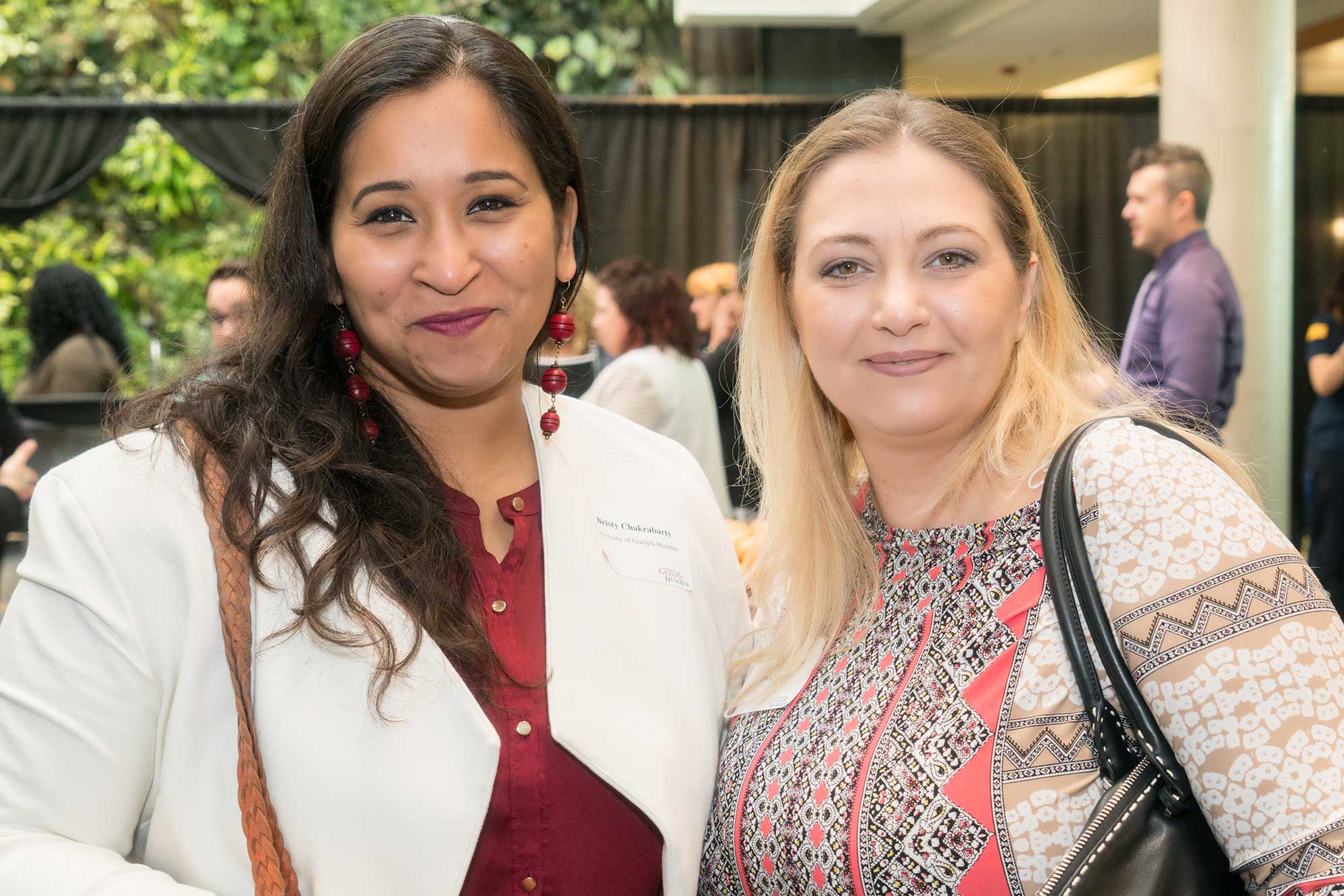 Two guests smile on campus