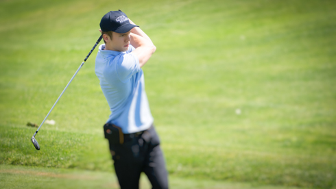 Photo of UofGH alumni swinging golf club