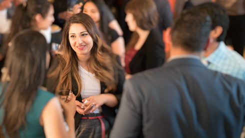 Large group of alumni in conversation during reception