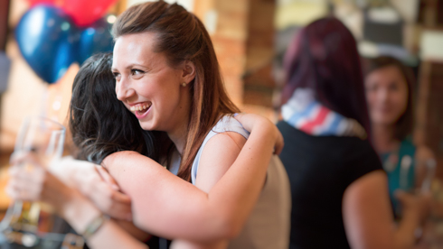 Two alumni embrace in hug