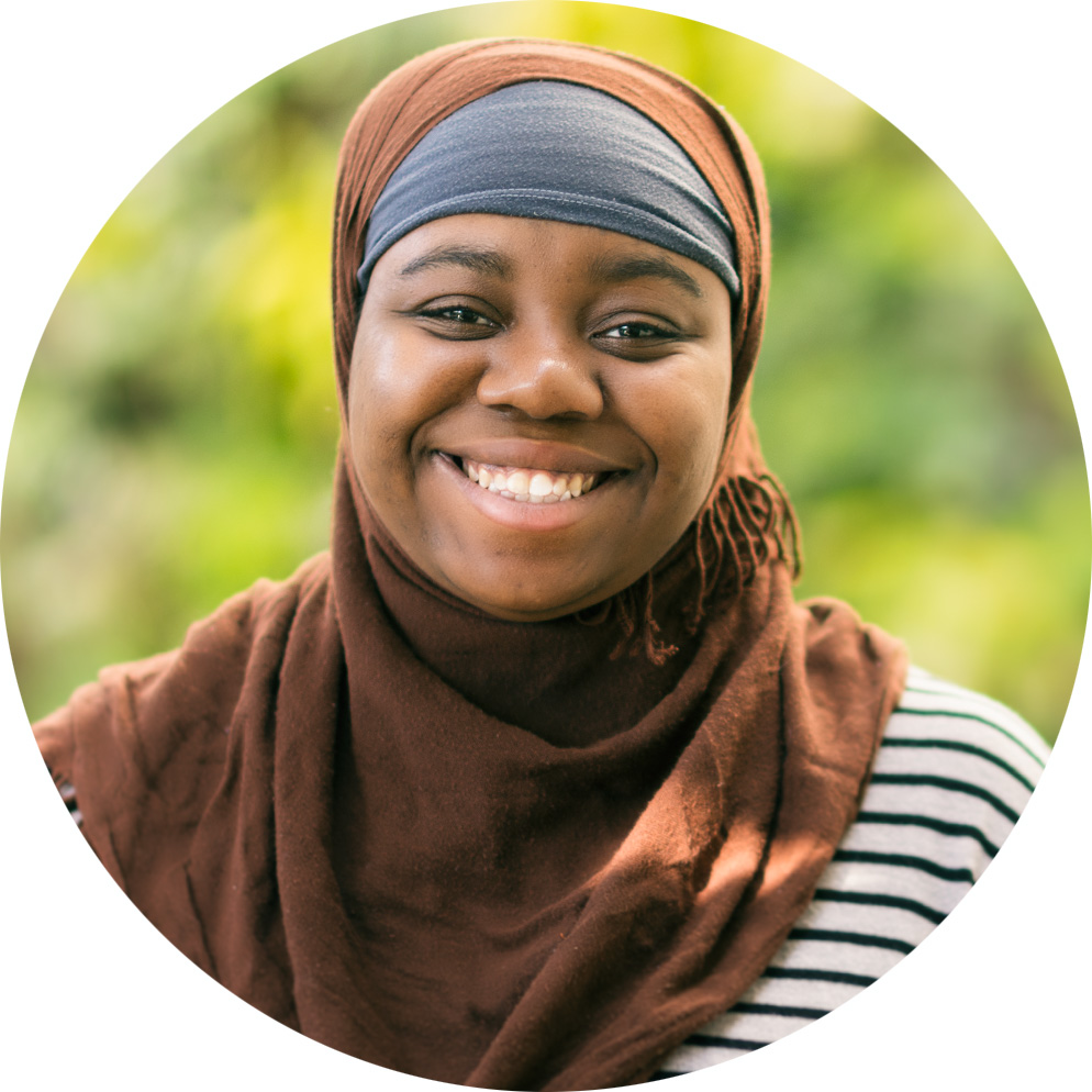 Ameerah McLean looks cheerful by the plant wall