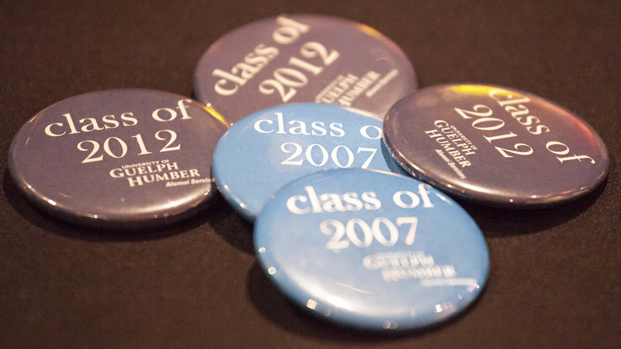 A pile of Class of 2007 and Class of 2012 buttons