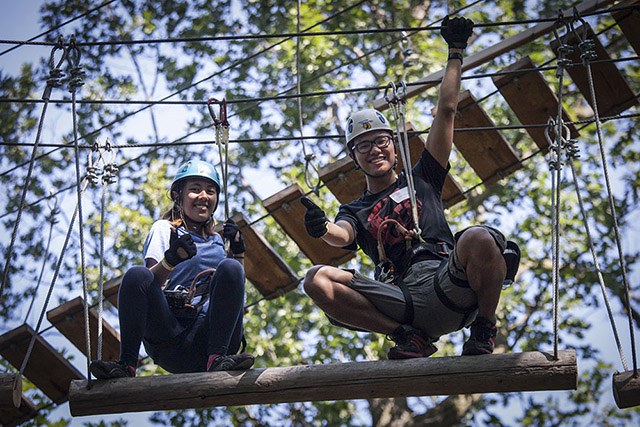 Two alumni smile on a slim platform