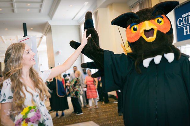 A graduate gives Swoop a high five