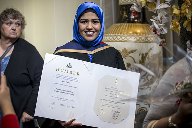 A graduate poses with her degree